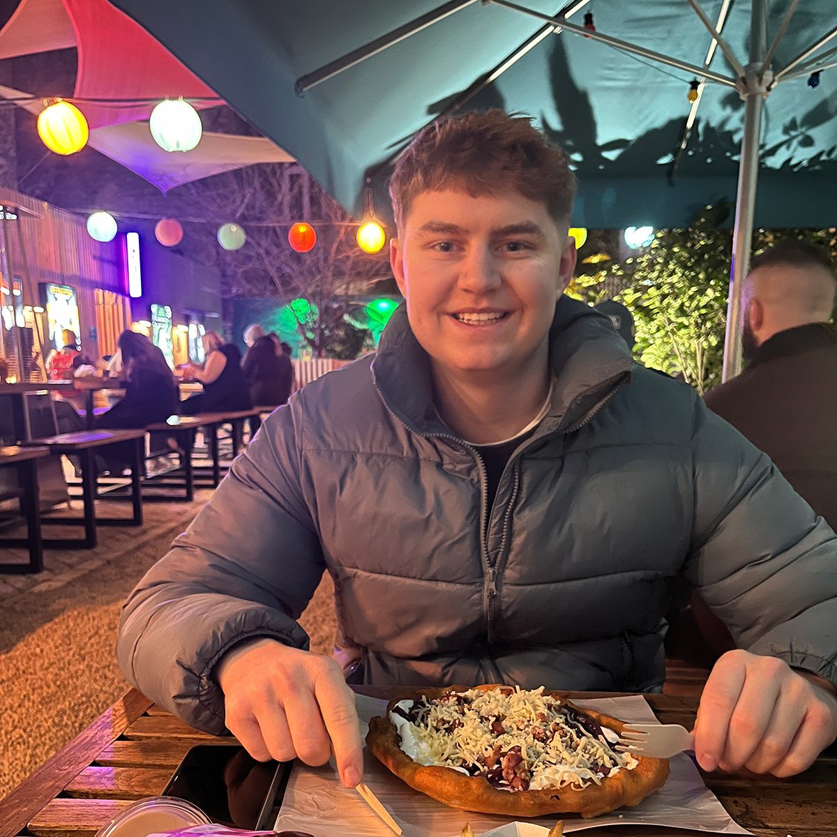 Enjoying a lángos with lots of toppings in Budapest